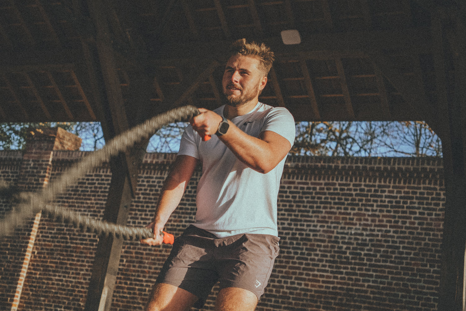 Consommateur de nutrition sportive Musclooor en plein effort avec une corde ondulatoire de crossfit