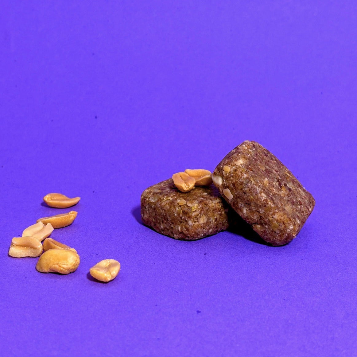 Barre énergétique Cahuète Power Salée à la cacahuète, riche en nutriments et idéale pour l’effort, avec des morceaux de cacahuètes visibles sur fond violet.
